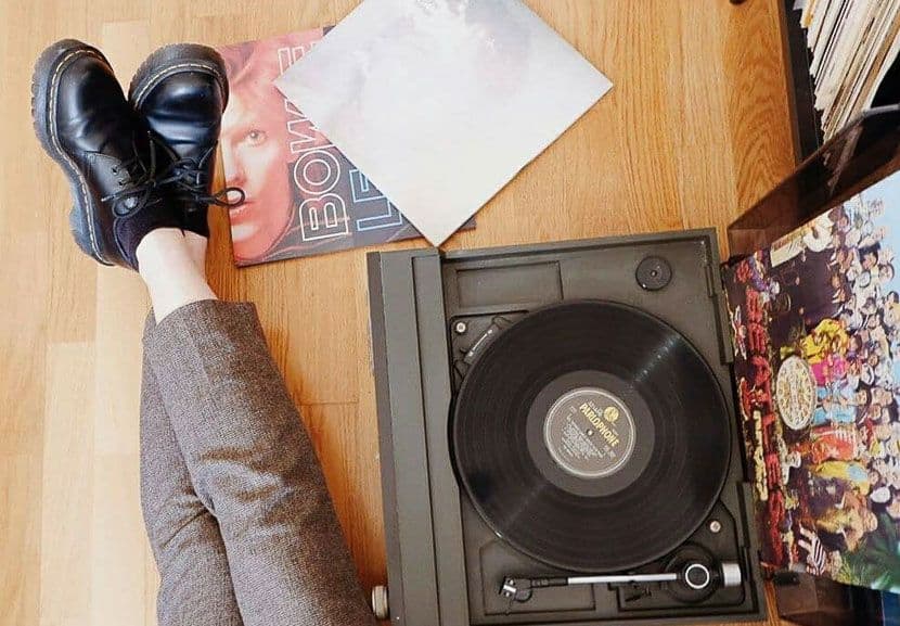 Woman sitting next to record player.